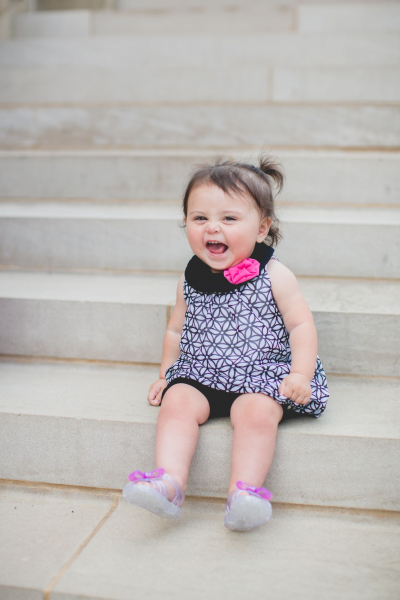 Baby girl sitting on some steps roaring loudly