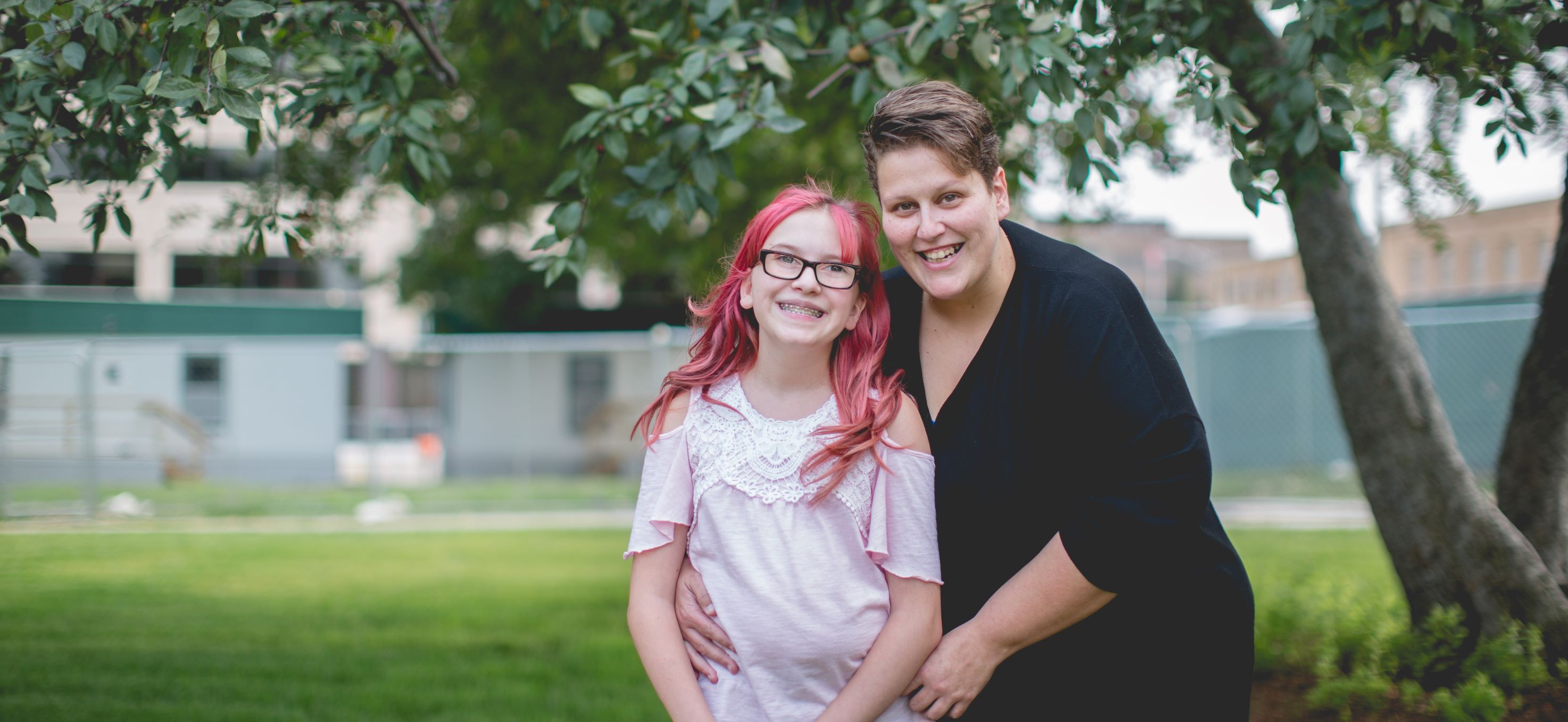 Mother and daughter hugging and smiling at camera