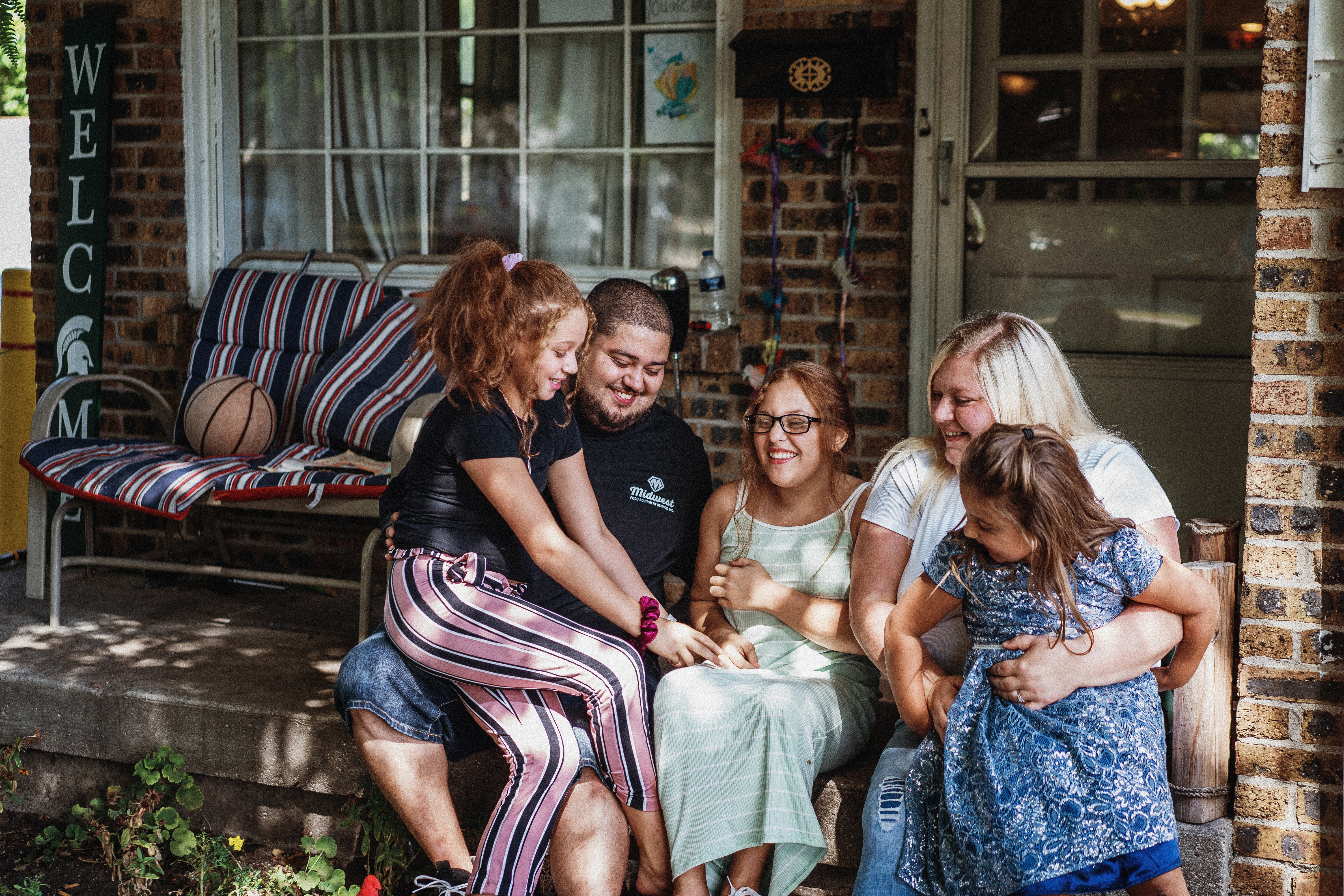 Family of five - mom, dad, three daughters - posing for a family photo