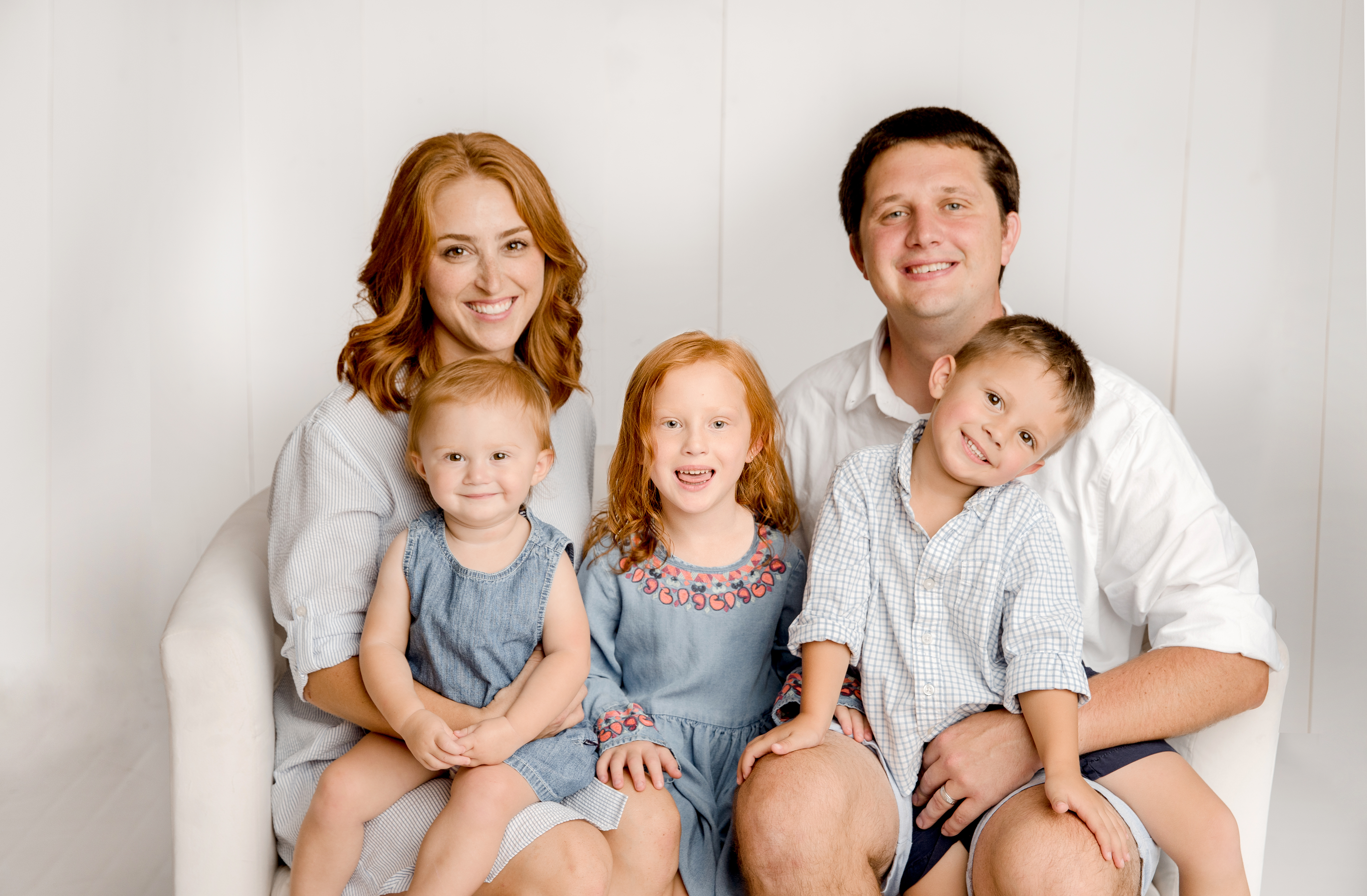 Family of five - mom, dad, two daughters and a son - posing for a family picture