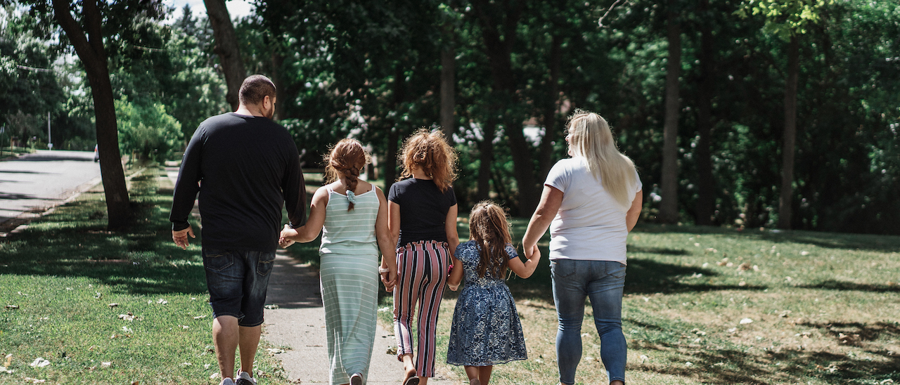 Family of five - mom, dad, three daughters all walking away from the camera