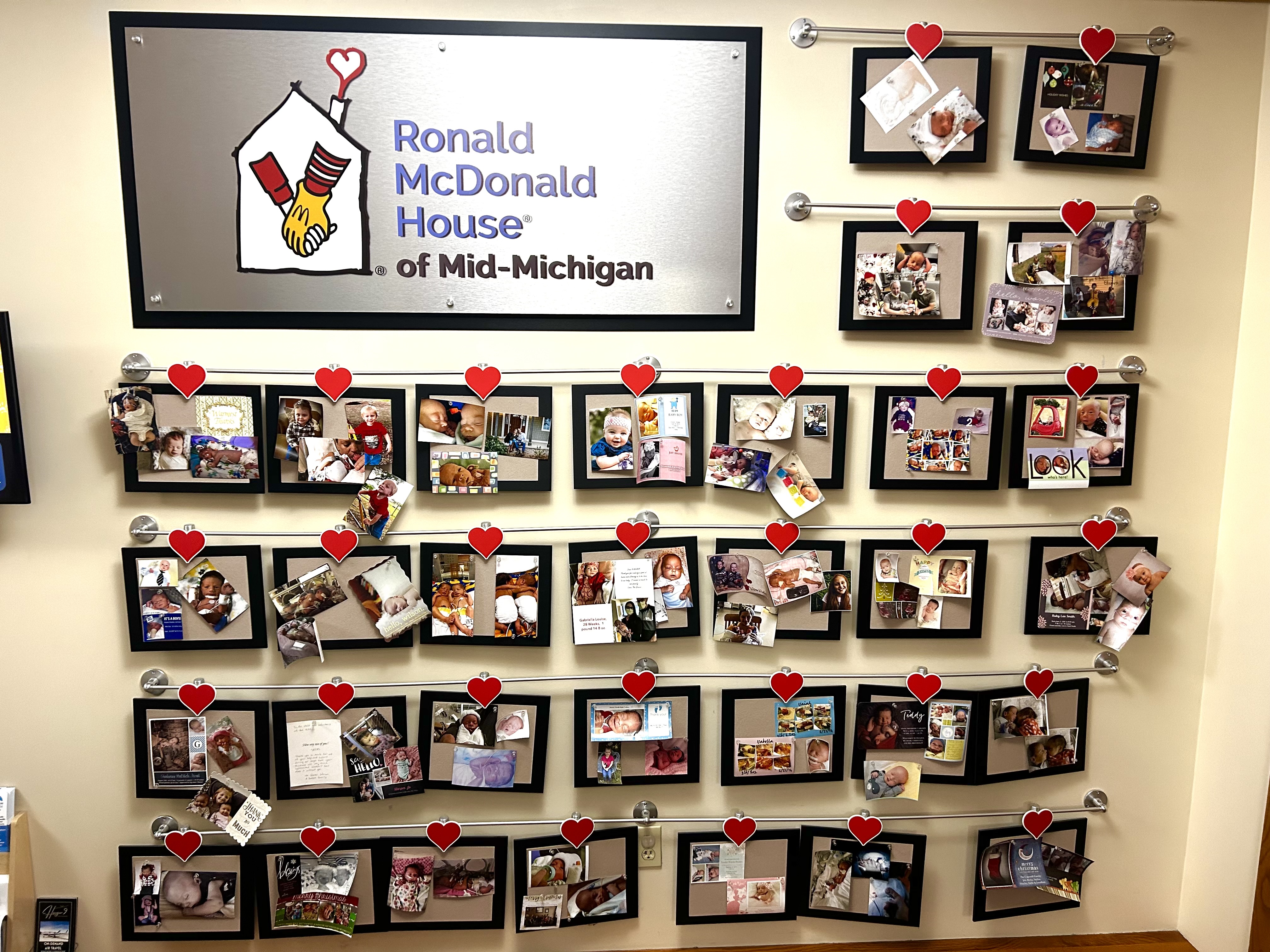 A wall of framed images of the children of the Ronald McDonald House