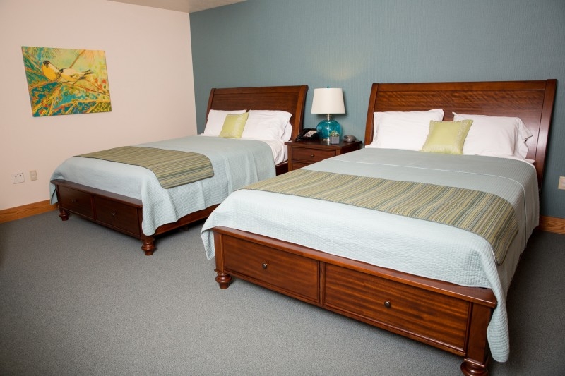 Two queen beds made neatly in preparation for future guests